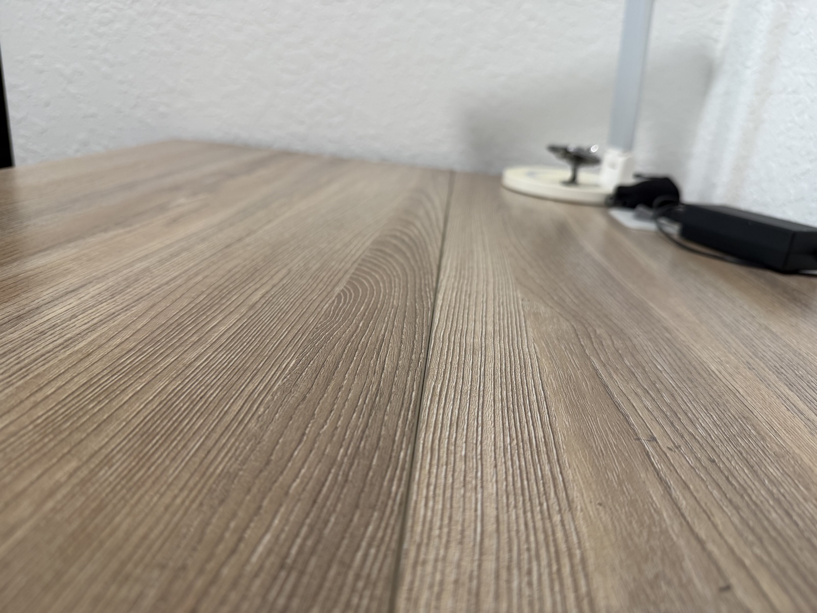 Close-up of the SHW desk's two-piece laminate top with a visible lengthwise join in the center.