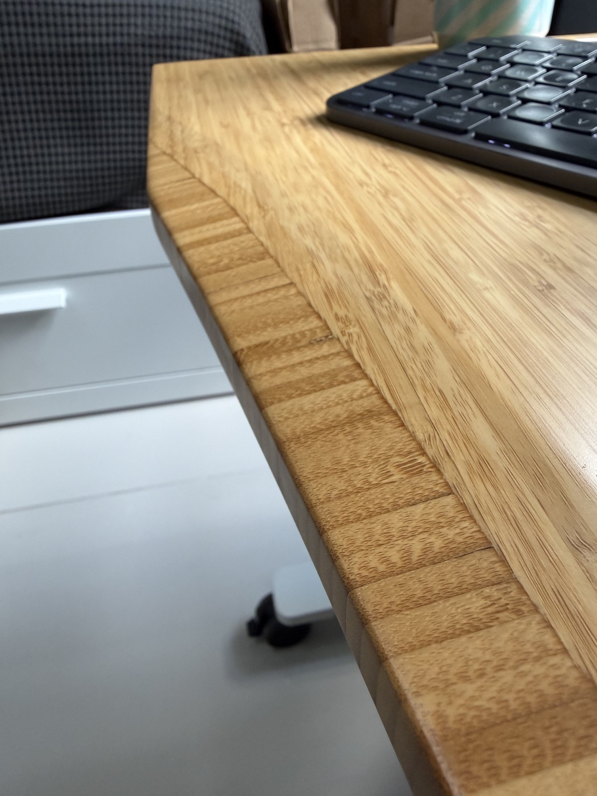 Close-up of the UPLIFT Bamboo Curve desktop showing its rounded front profile.